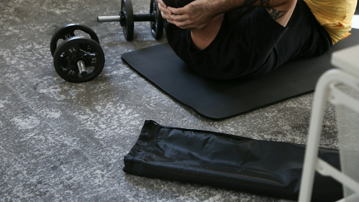 a man is doing exercises on a mat with a barbell